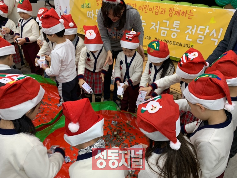 송정동 민간어린이집 원아들이 저금통을 전달하고 있다