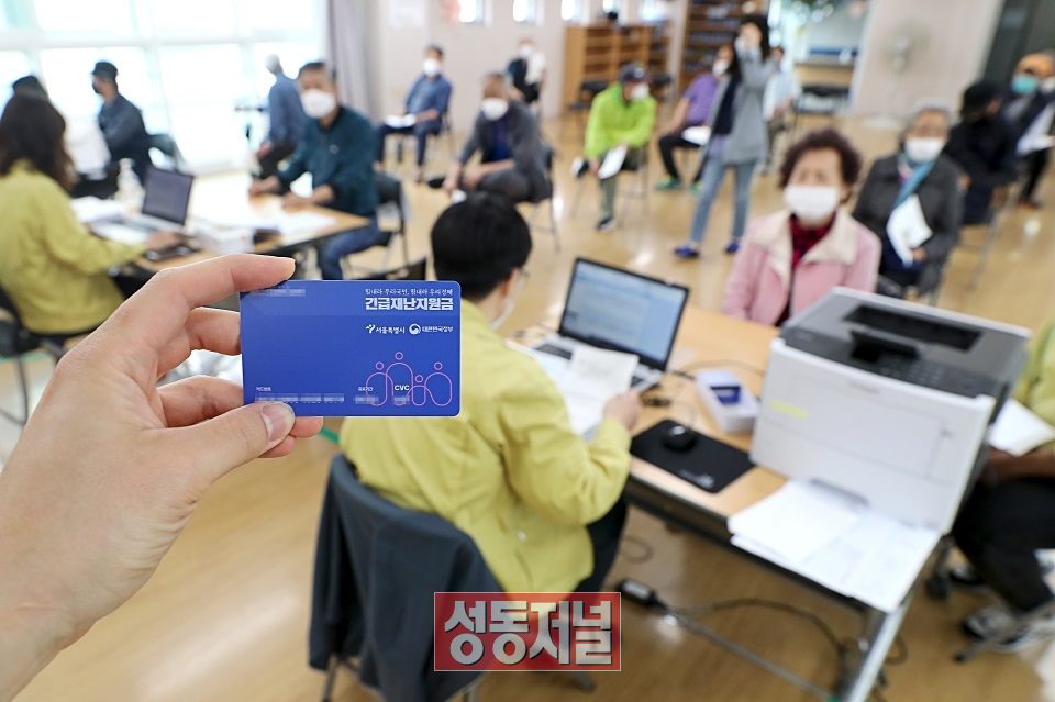 18일 오후 서울 성동구 금호2-3가동 주민센터 직원이 정부 긴급재난지원금 선불카드를 지급하고 있다.