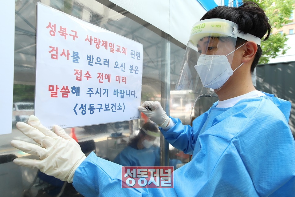 19일 오후 서울 성동구 선별진료소에 수도권 지역감염으로 인한 검사량이 많아짐에 따라 성동구 관계자가 안내문을 붙이고있다.