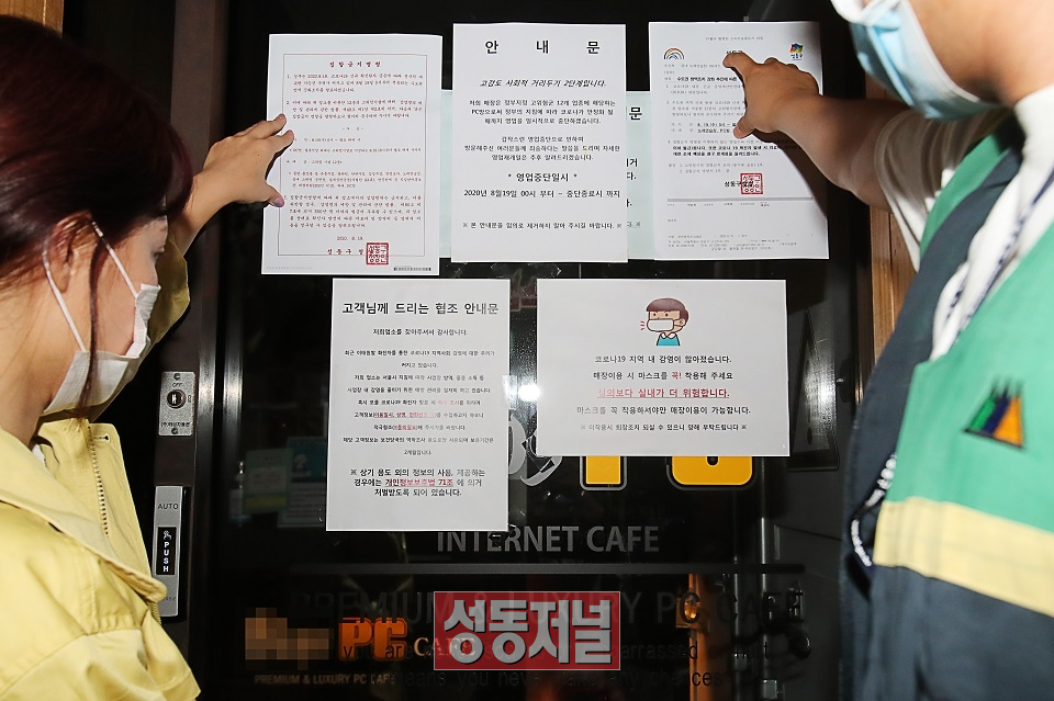 20일 오후 서울 성동구청 문화체육과 직원들이 고위험시설로 분류된 관내 PC방에 집합금지명령서를 붙이고 있다.
